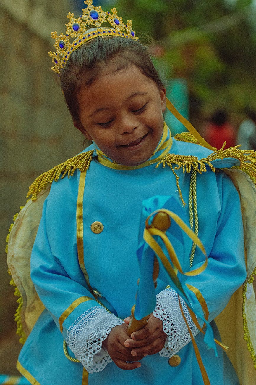 A young person smiling, dressed in a festive costume, representing inclusive care