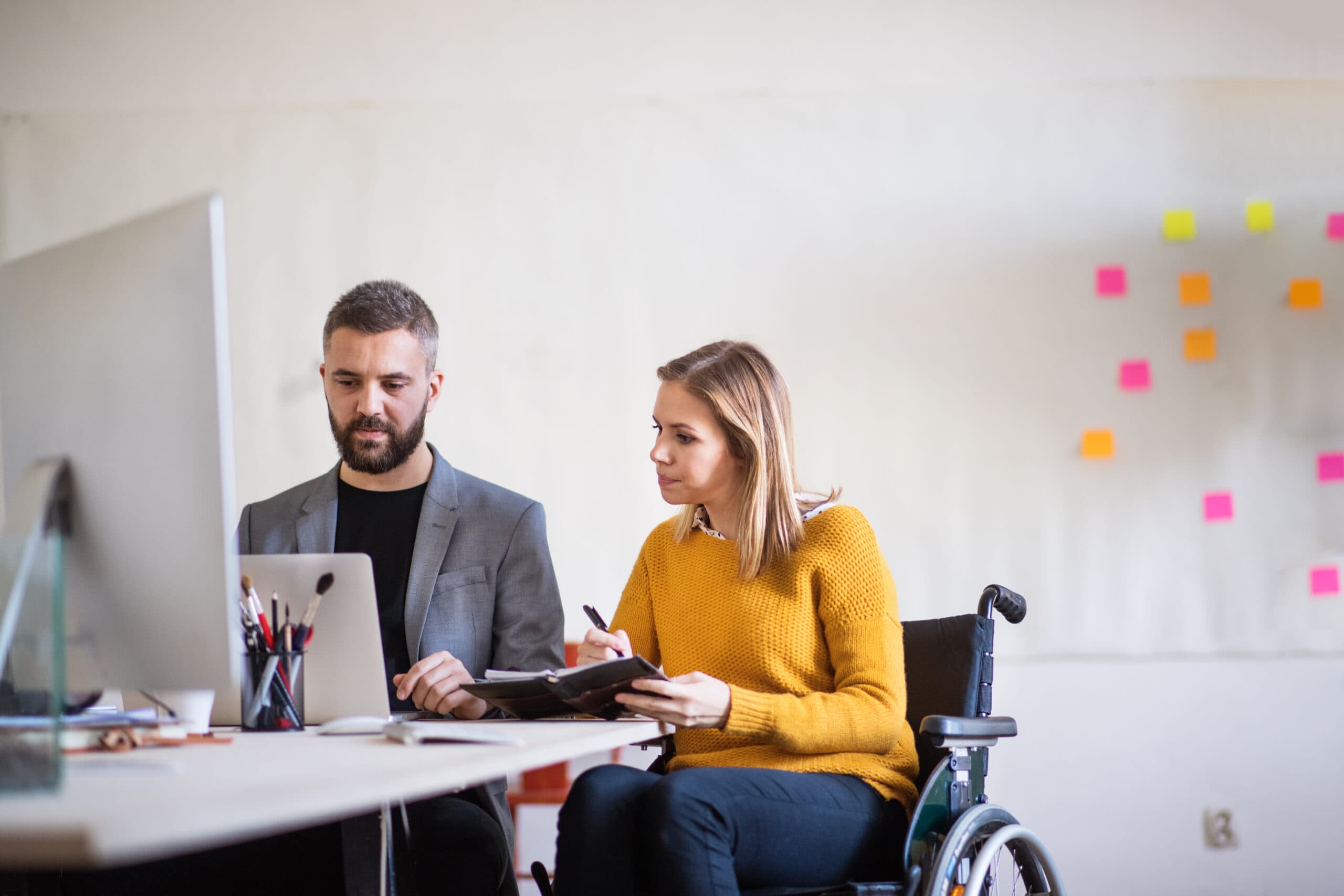staff and participant sitting in a wheel chair having conversation